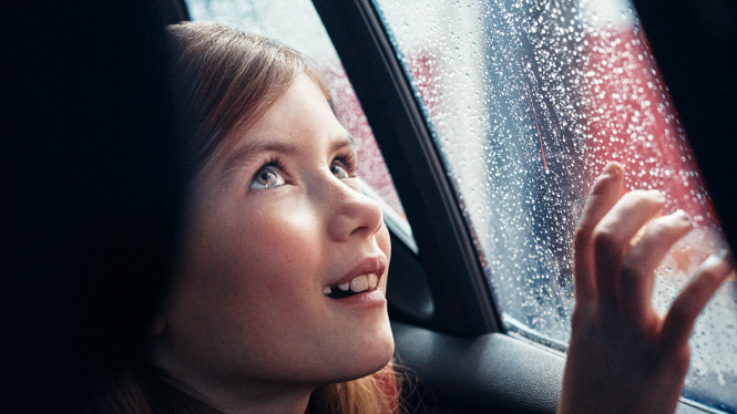 A girl looking out of the window during a car wash