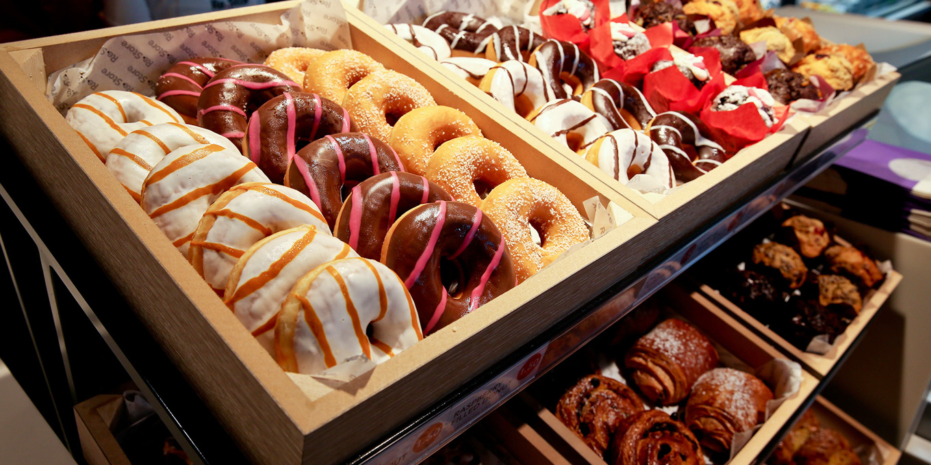 A selection of iced ringed donuts in a display stand