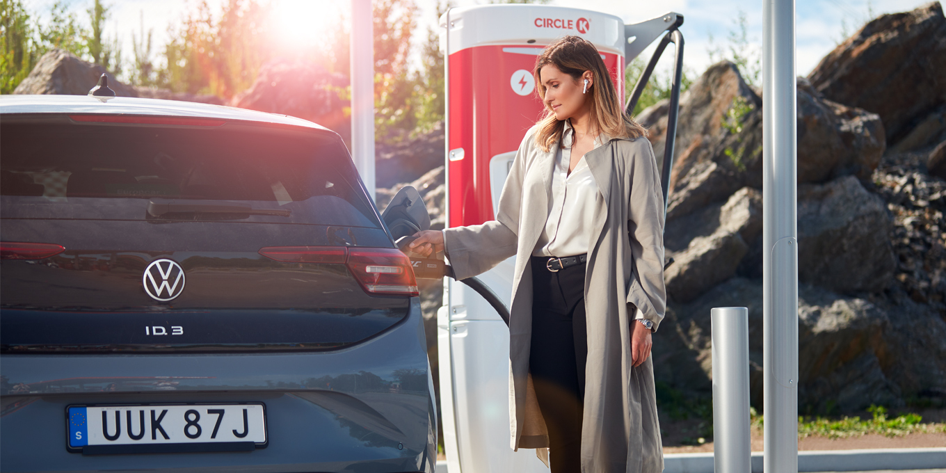Woman charging an electric car at a Circle K EV charging point