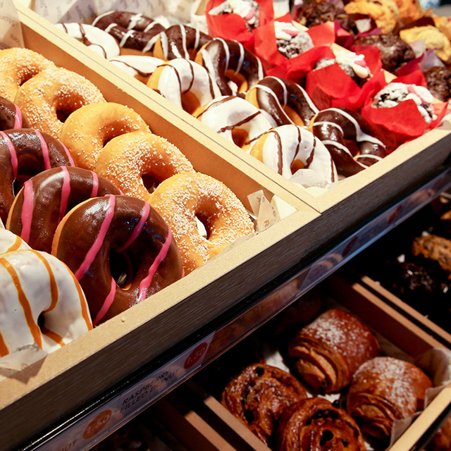 A selection of iced ringed donuts in a display stand