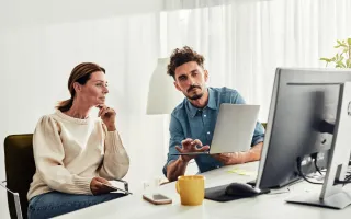 Person showing woman how to use customer portal on computer