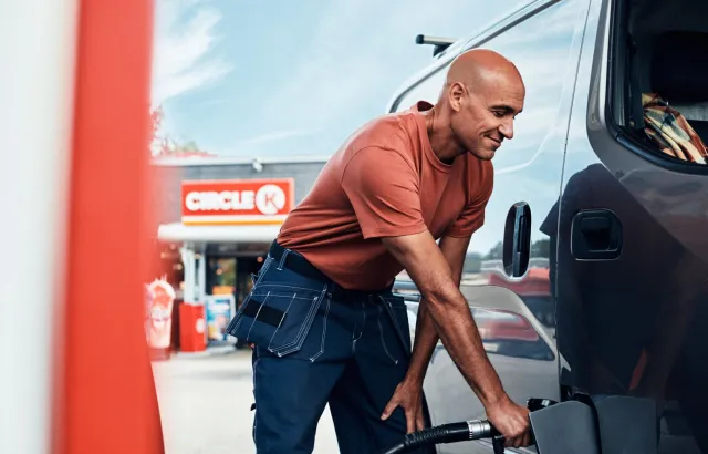 Man happily fueling his van at a Circle K station