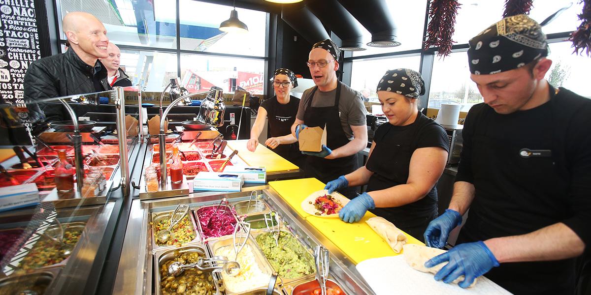 Employees making sandwiches at the deli counter